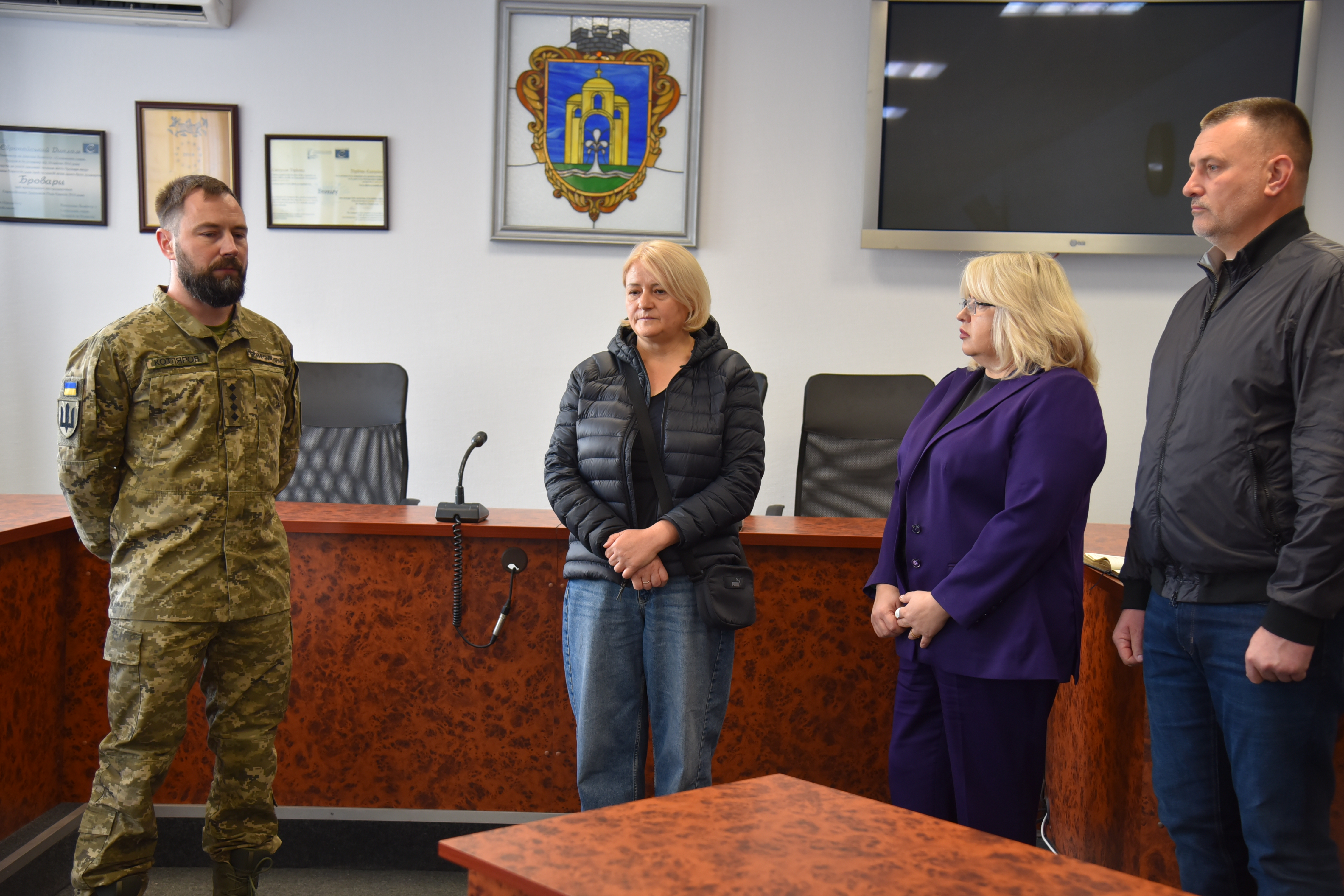 Офіційна зустріч зблизька: ліворуч стоїть військовий із нашивкою ЗСУ, навпроти нього в ряд — двоє жінок та чоловік у повсякденному одязі.